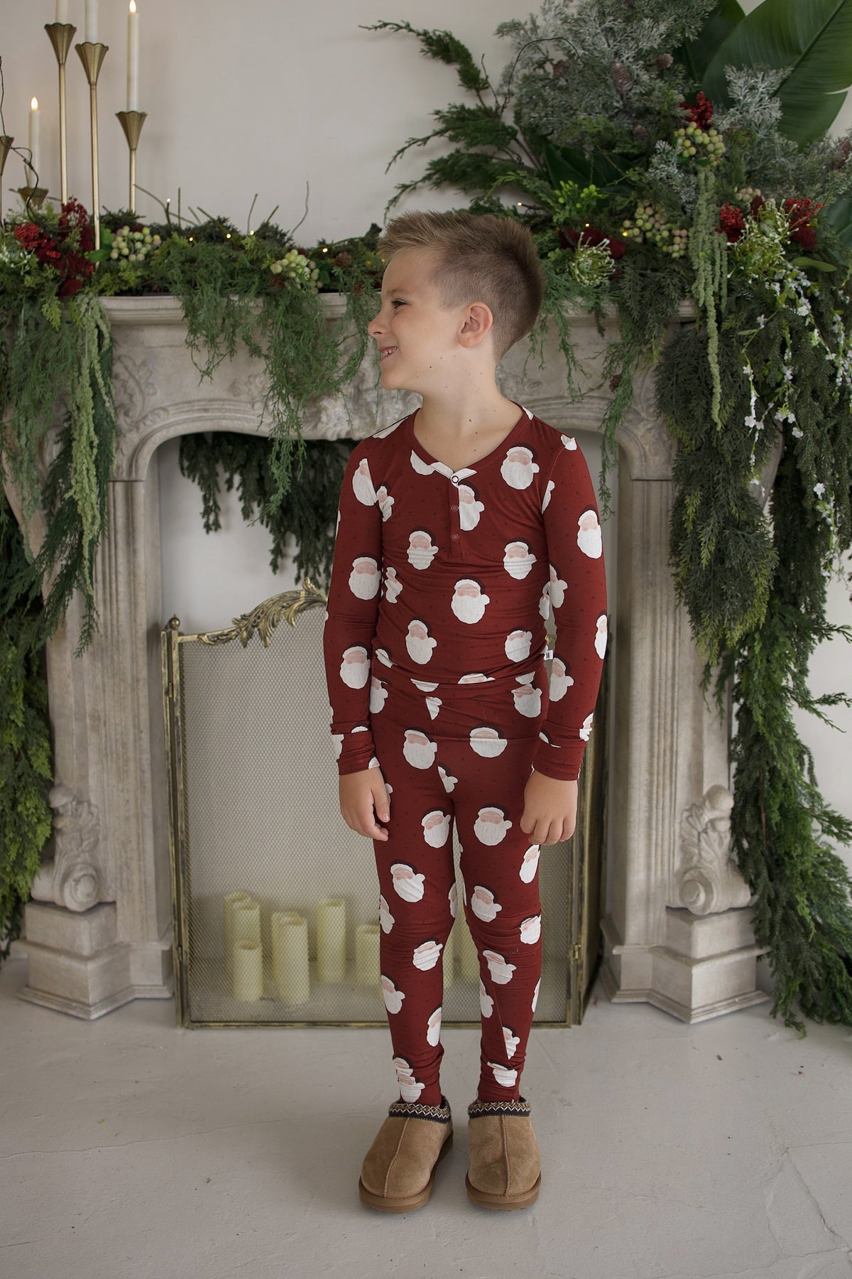 A young boy wearing burgundy Bamboo Two Piece Pajamas | Vintage Santa with a white Santa Claus print.