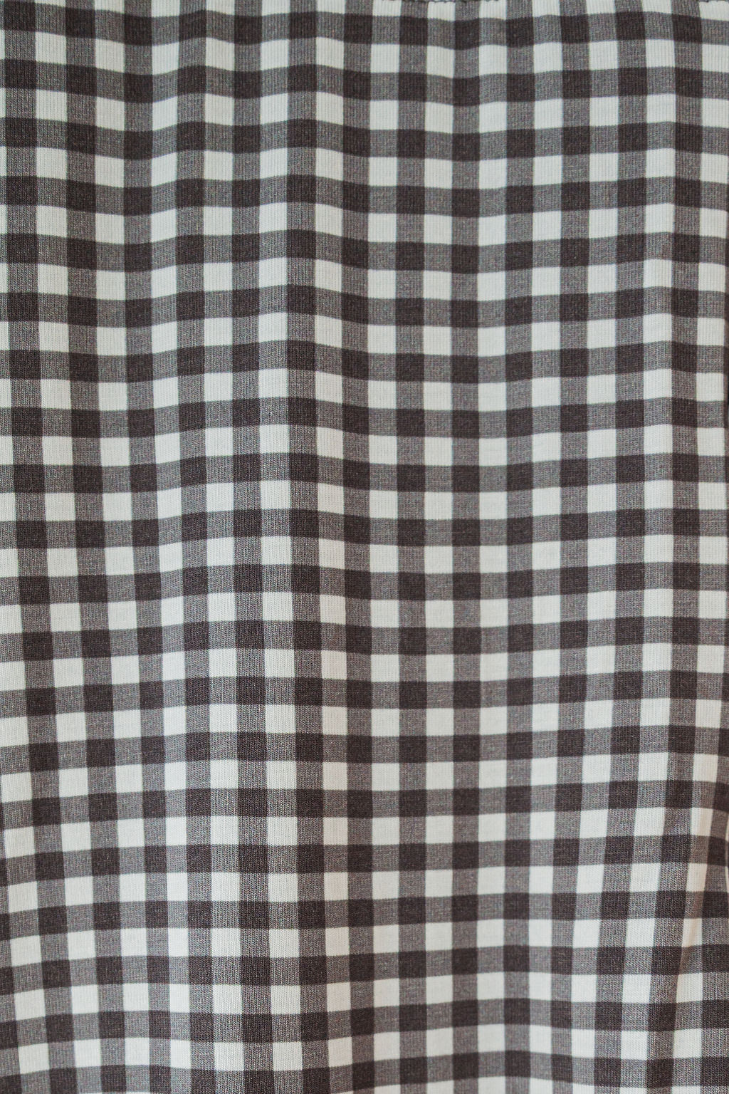 A close-up of the green gingham Women's Boxy Tee Lounge Set from forever french baby, featuring a hypo-allergenic bamboo fabric with a classic checkered pattern formed by evenly spaced horizontal and vertical lines.