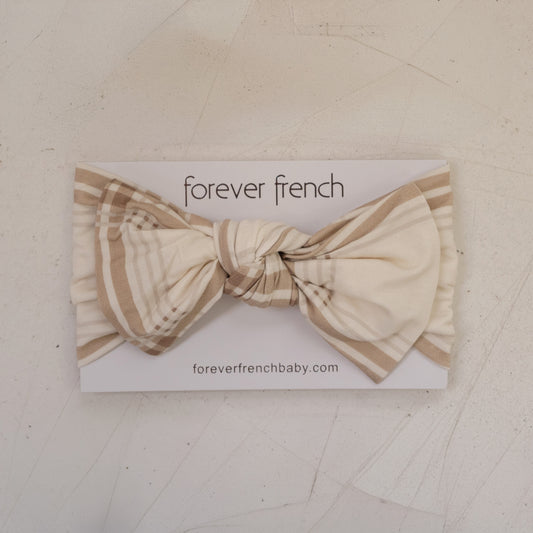 The Bamboo Head Wrap | Ellis Plaid by forever french baby is tied in a bow and displayed on a branded card with "foreverfrenchbaby.com," set on a light textured background.
