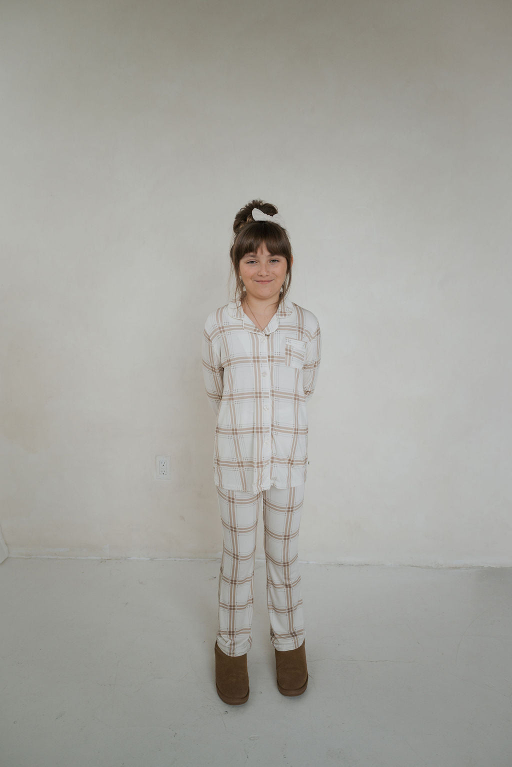 A girl wearing a white and tan Ellis Plaid bamboo button-up lounge set.
