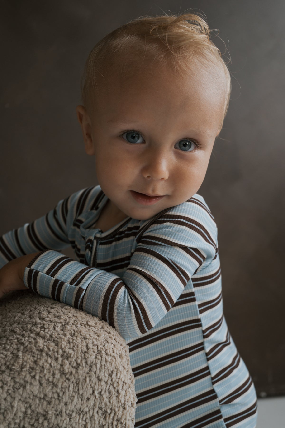A young child wearing blue and brown striped long-sleeve Bamboo Zip Pajamas | Dean.