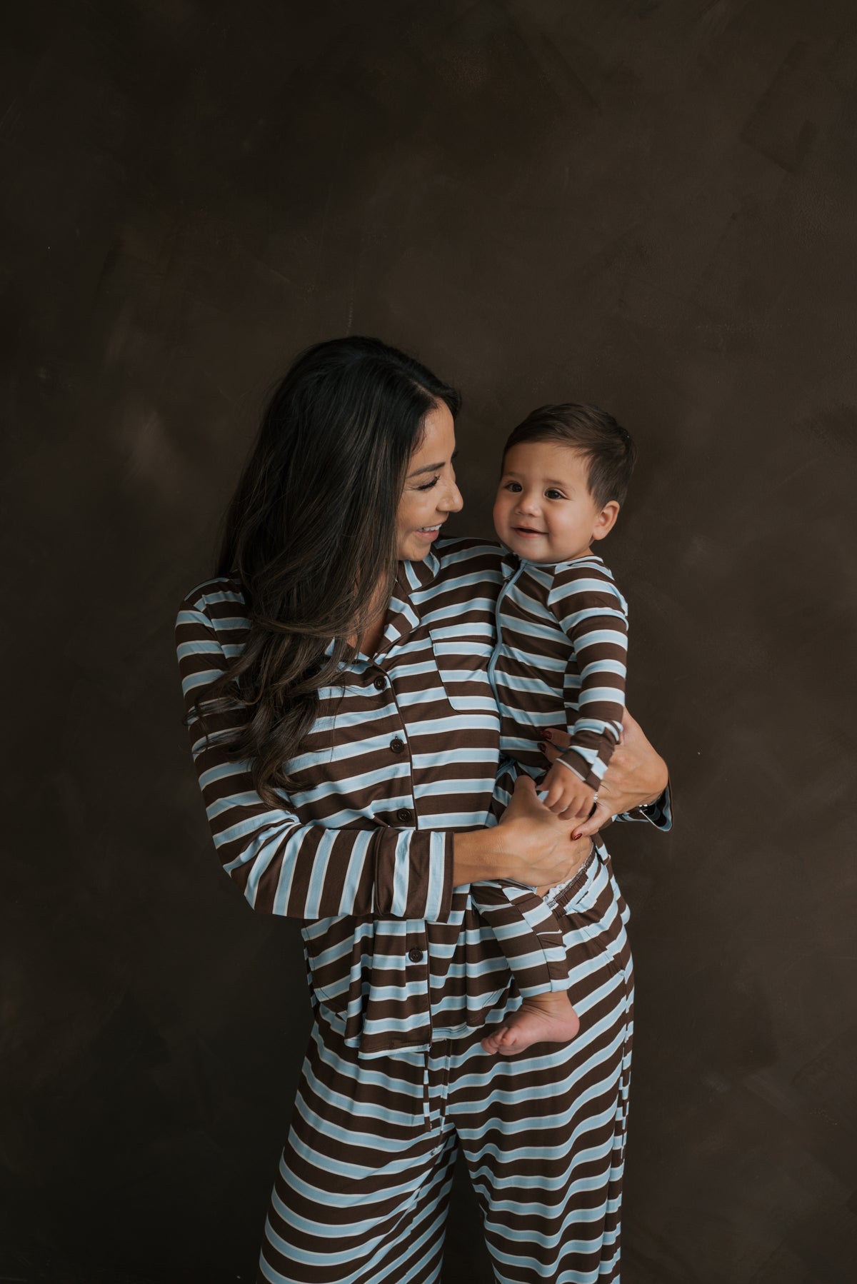 A woman and a young child wearing matching brown and blue striped Bamboo Zip Pajamas | Garrett.