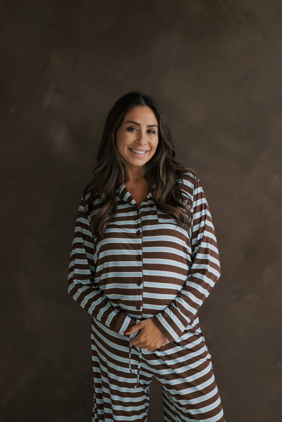 A smiling pregnant woman wearing a Women’s Bamboo Button Up Lounge Set | Garrett featuring blue and brown horizontal stripes.