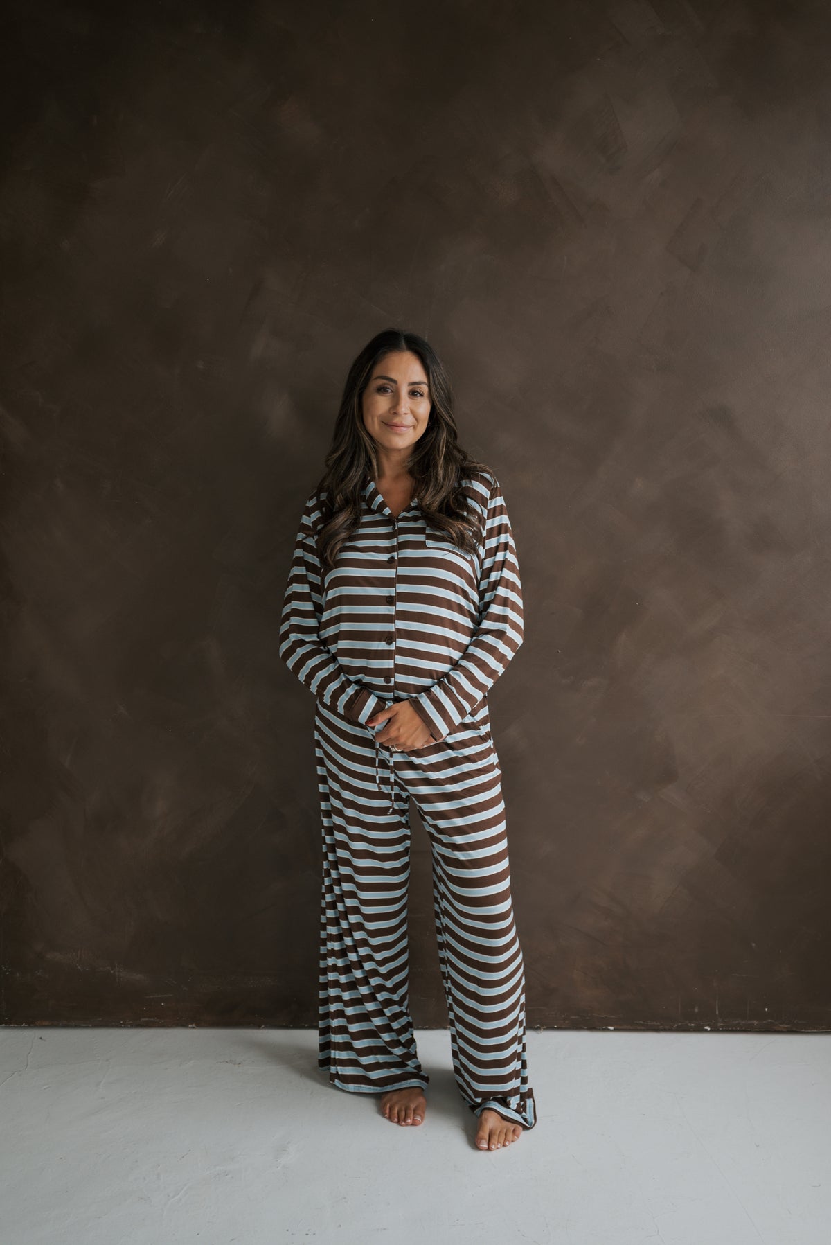 A woman wearing a brown and light blue striped Women’s Bamboo Button Up Lounge Set | Garrett.