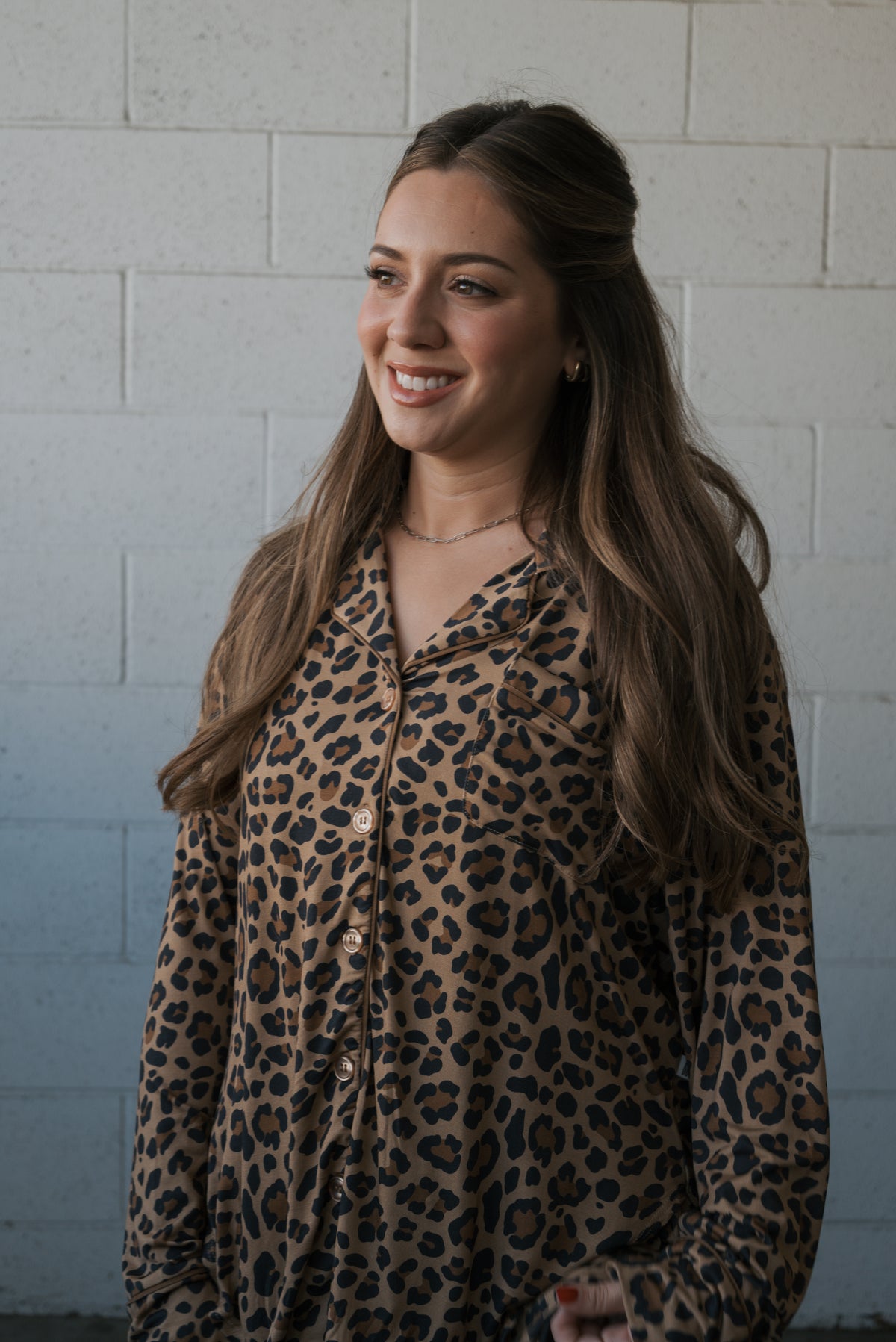 A woman smiling while wearing a long-sleeved, hypo-allergenic Women’s Bamboo Button Up Lounge Set | Leopard with a leopard print pattern.