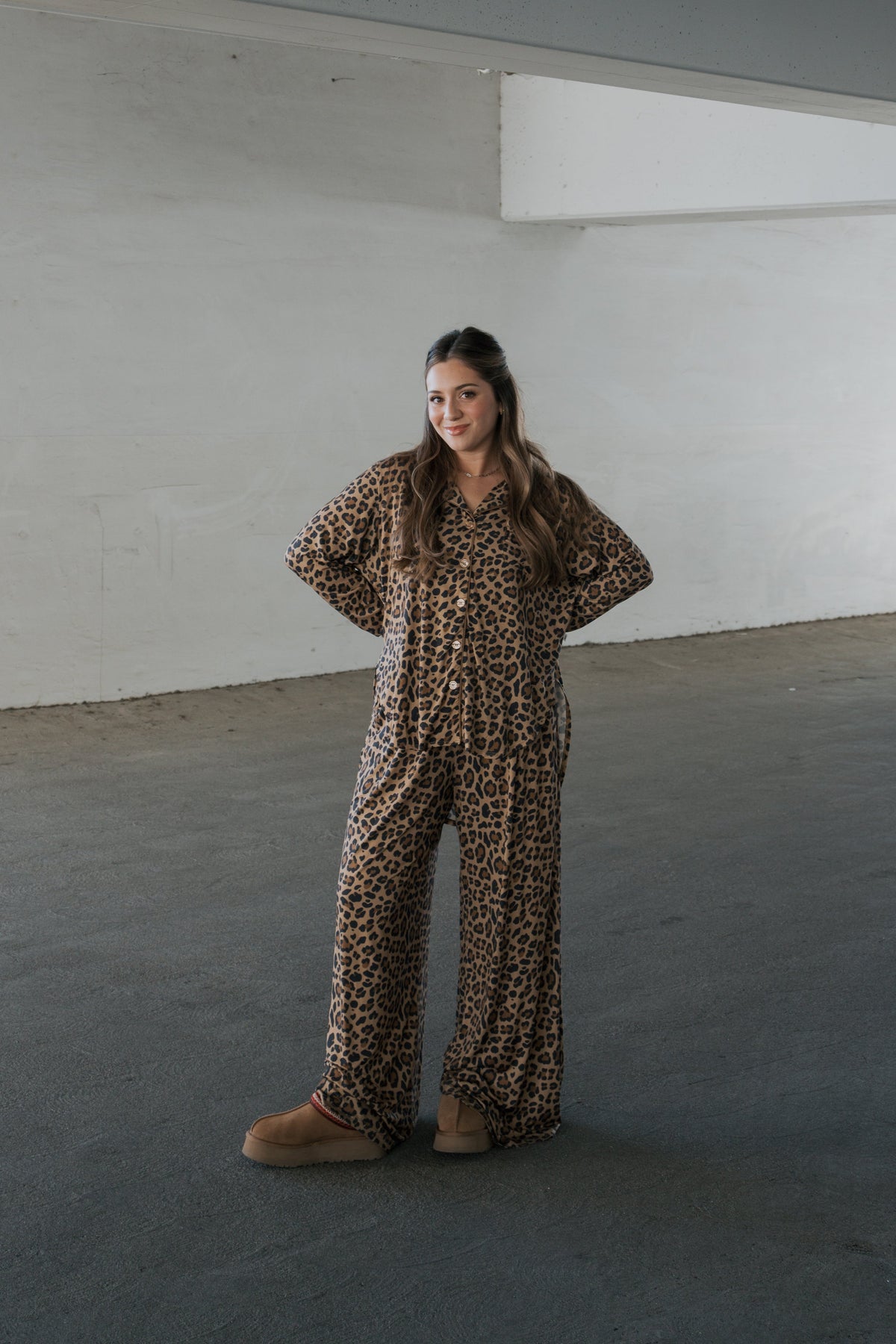 A woman wearing a forever french baby Women’s Bamboo Button Up Lounge Set in leopard print, featuring a button-up shirt and matching wide-leg trousers, styled with tan platform slippers.