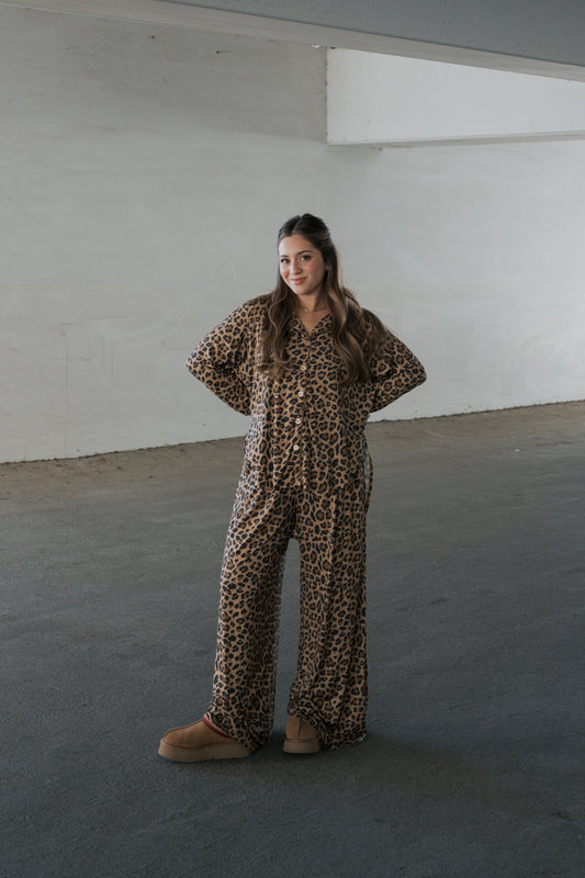 A woman wearing a forever french baby Women’s Bamboo Button Up Lounge Set in leopard print, featuring a button-up shirt and matching wide-leg trousers, styled with tan platform slippers.