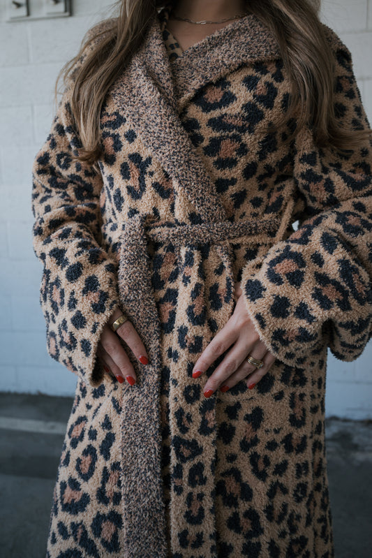 A person wearing a fuzzy, leopard-print belted microfiber Adult Robe | Leopard.
