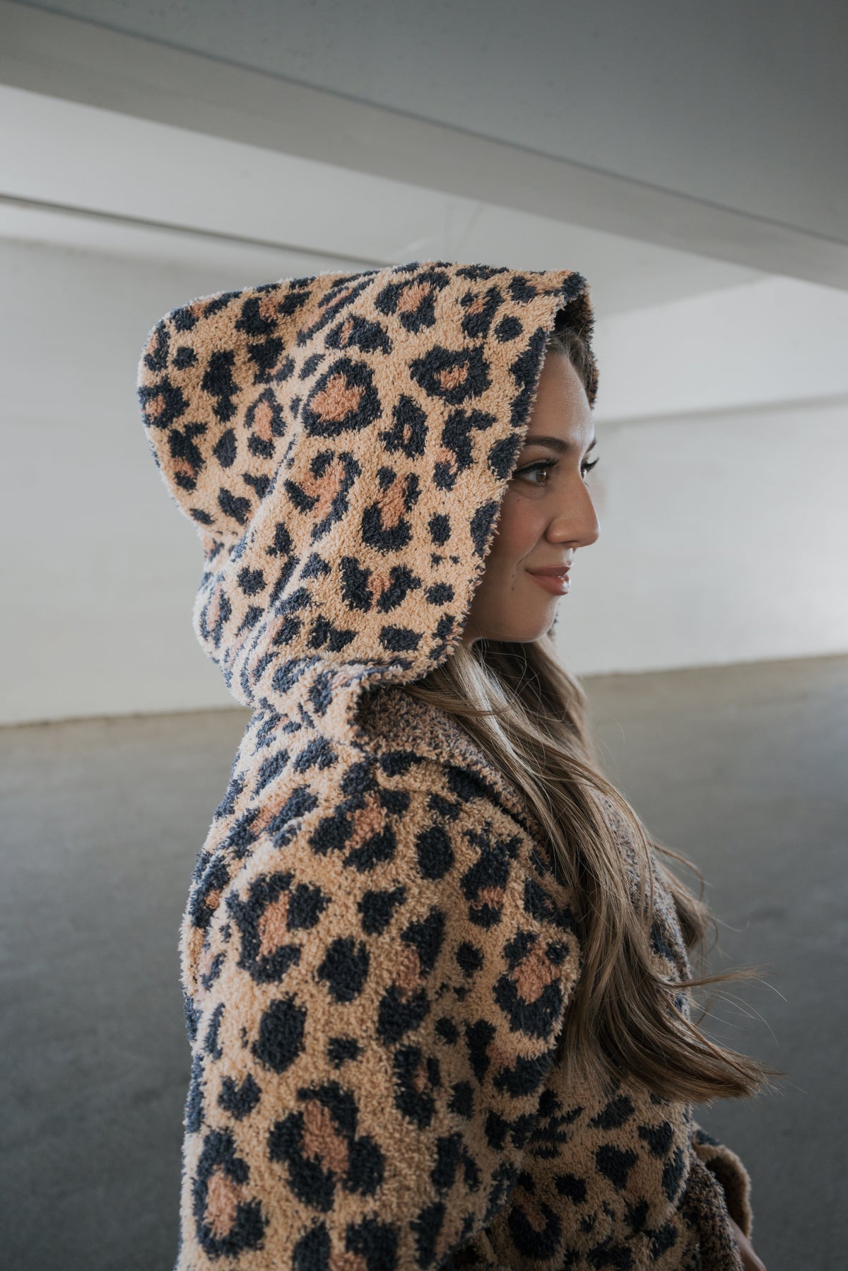 A person in profile wearing a hooded Adult Robe | Leopard in leopard-print microfiber.
