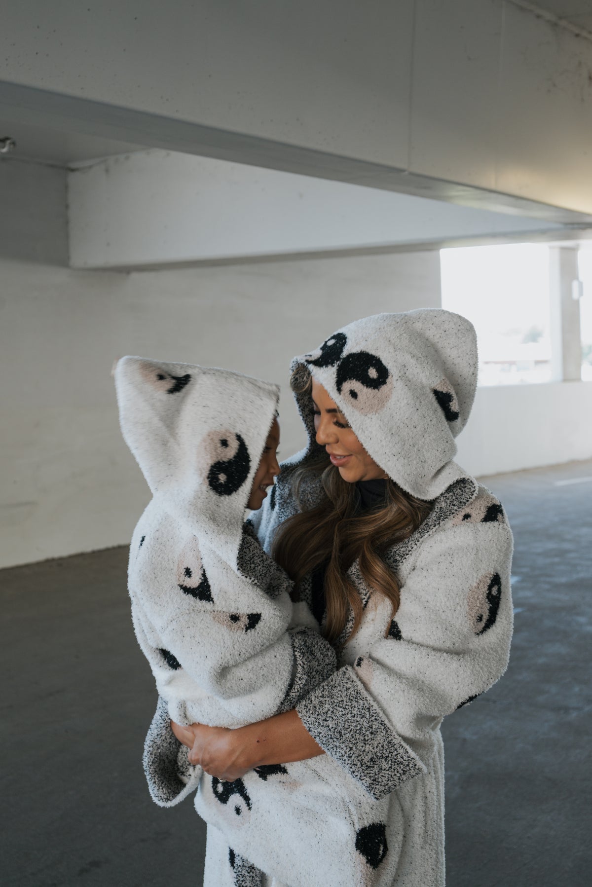 A woman and child wearing matching Oeko-tex certified Children’s Robe | Yin Yang hooded robes featuring a black and white yin-yang pattern.