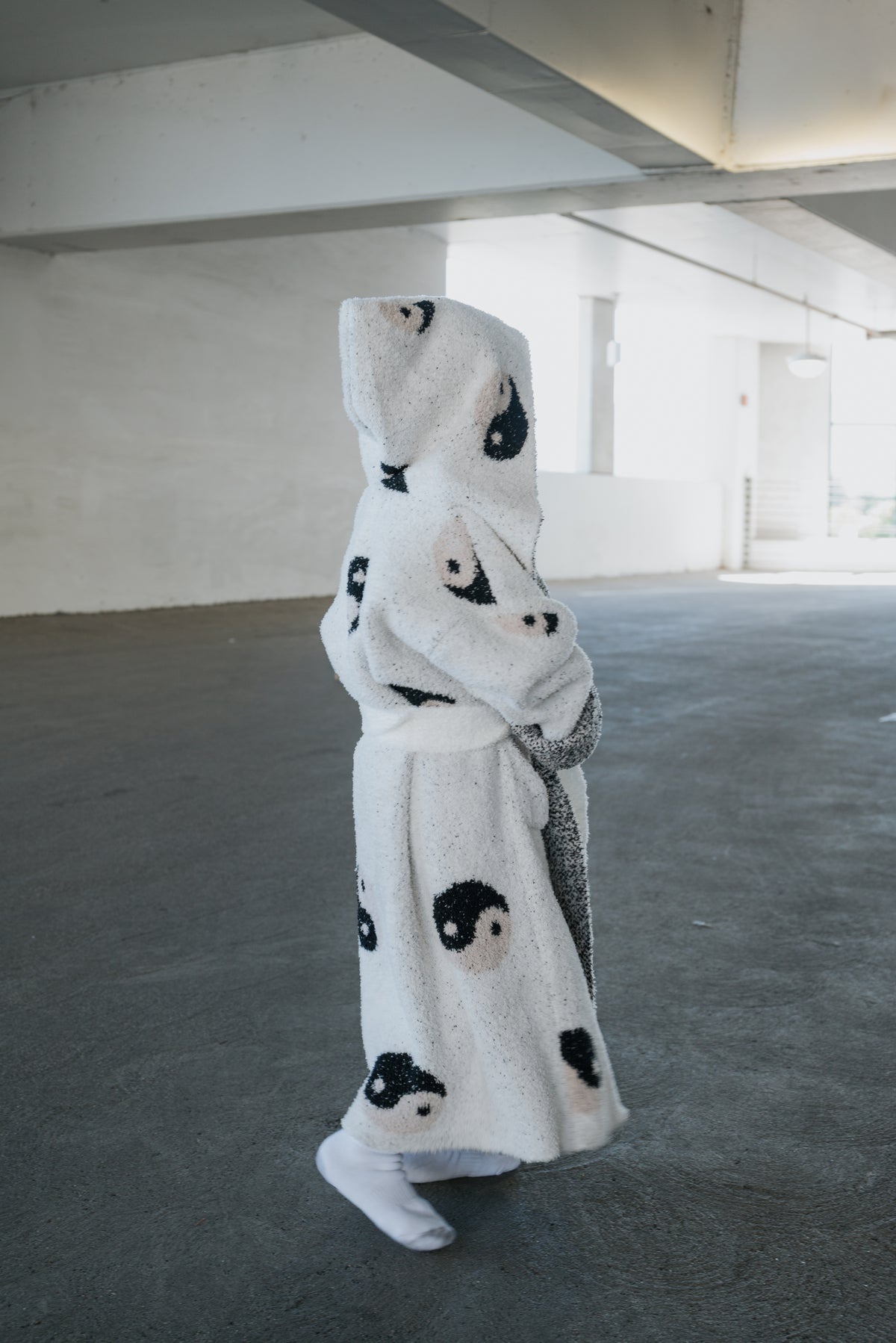 Child wearing a Children’s Robe | Yin Yang, a microfiber feather yarn hooded robe patterned with black and tan yin yang symbols.