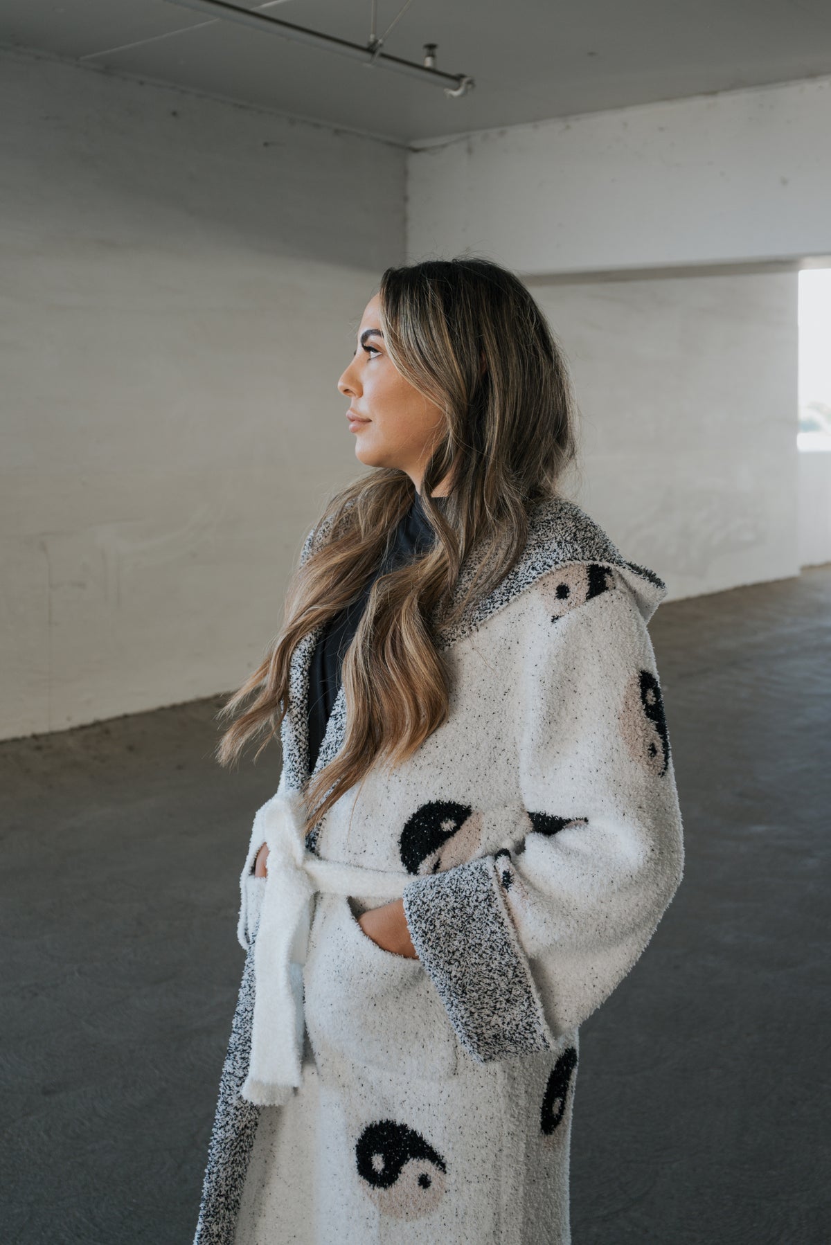 A person wearing a forever french baby Adult Robe | Yin Yang, featuring a microfiber fabric patterned with black and white yin-yang symbols.