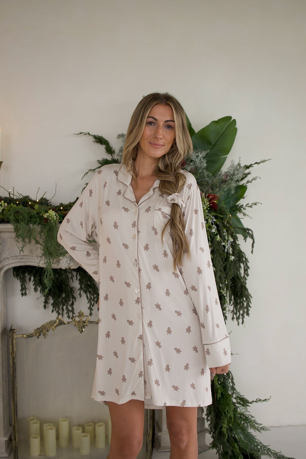 Woman wearing a Women’s Bamboo Sleeping Dress | Gingersnap, a long-sleeved, button-down dress featuring a brown gingerbread man print.