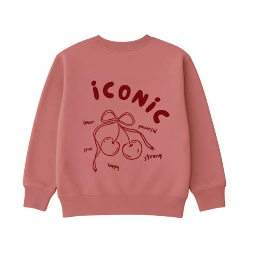 The Women's Sweatshirt | Iconic (Pre-Order) by Minty Cherries is a pink crewneck featuring "ICONIC" in bold red above a hand-drawn cherry and bow print, surrounded by words like "lover," "free," and "strong.