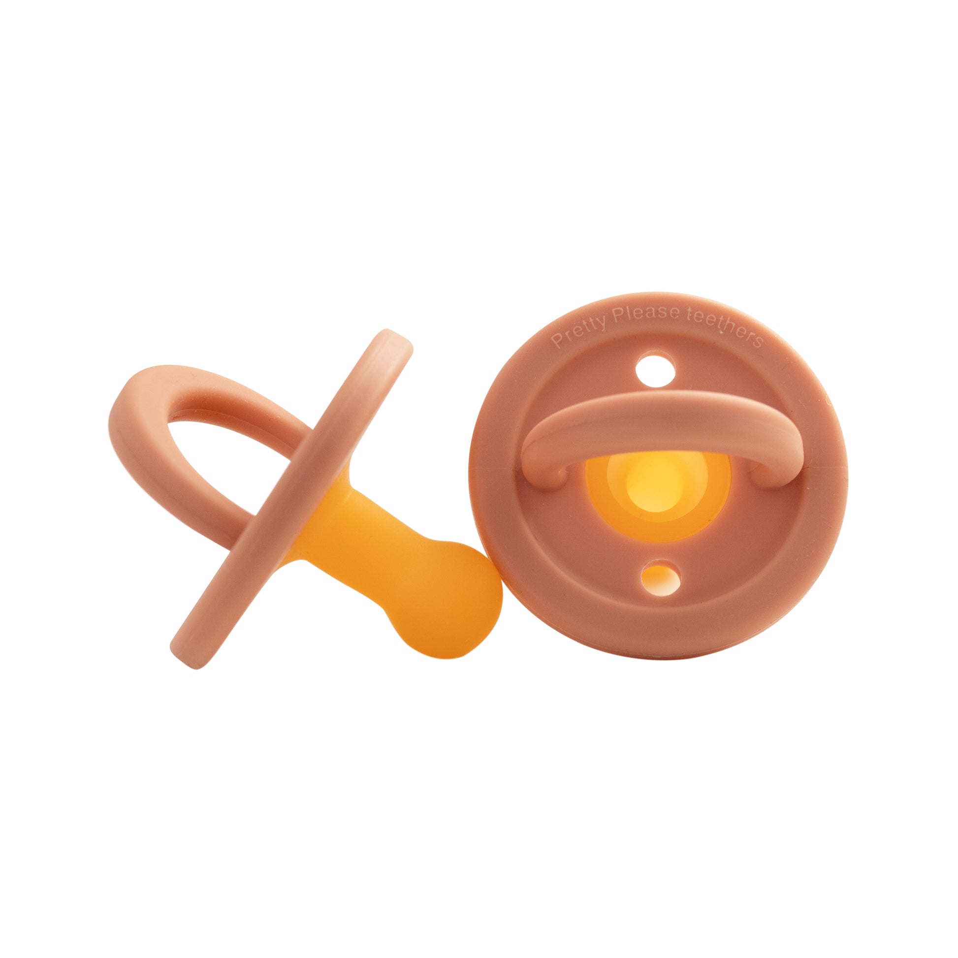 Two "Modern Pacifier | Sandstone" by forever french baby, one positioned upright with a yellow silicone nipple and the other lying down showing the backside. The design is simple and clean—perfect baby essentials.