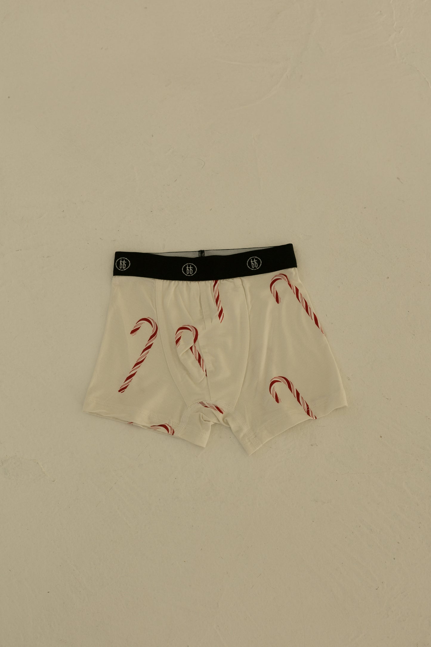 The forever french baby Bamboo Boxers (3 Pack) in Red Gingham, Candy Cane, & Santa Checkerboard offer hypoallergenic, stylish, and comfortable underwear with a black waistband and festive prints.
