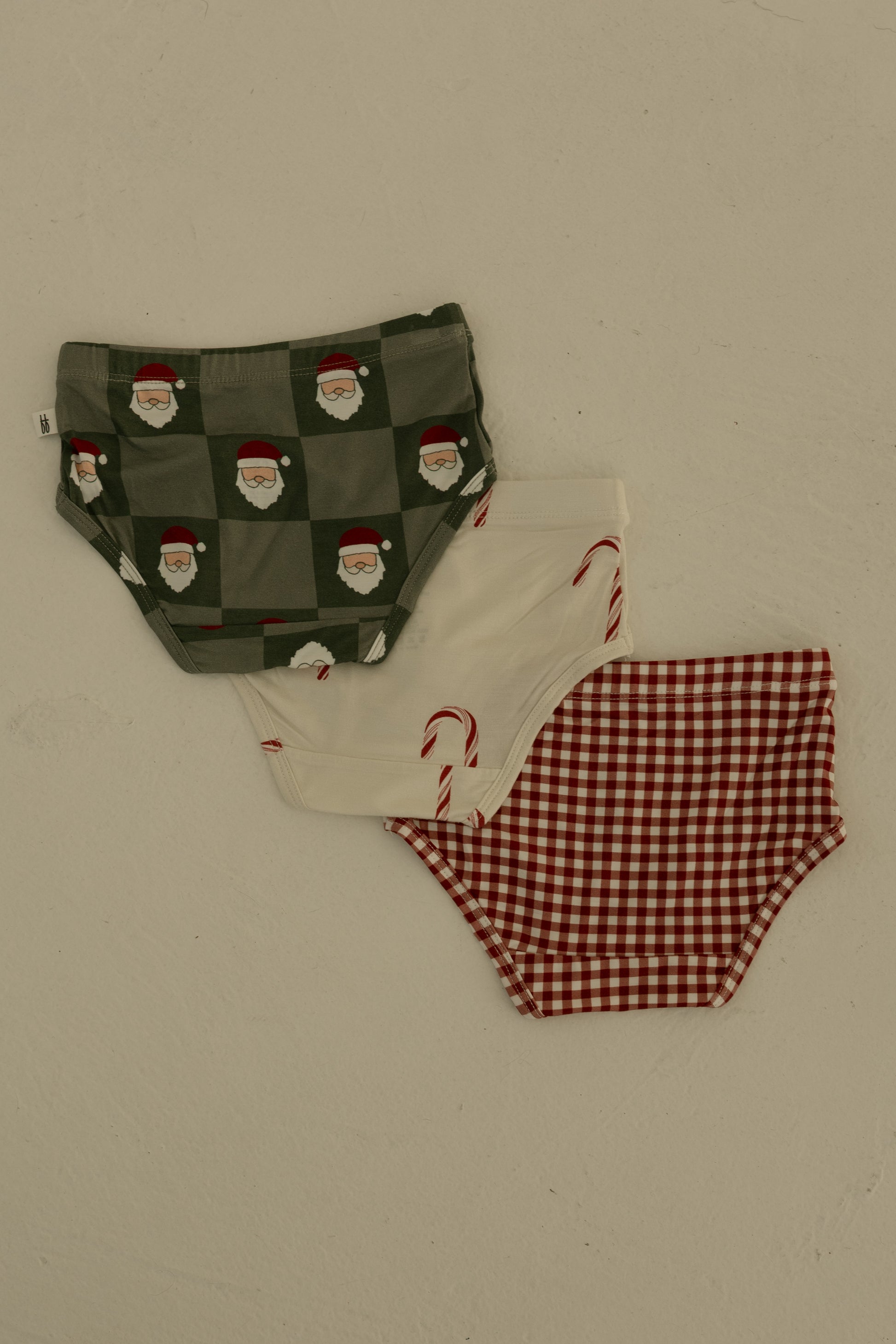 The forever french baby Girl's Bamboo Briefs (3 Pack) includes red gingham, candy cane, and Santa checkerboard designs. Made from soft, hypo-allergenic bamboo for girls.