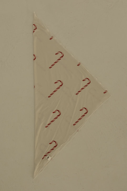 The Bamboo Bandana | Candy Cane by forever french baby is a cream-colored, triangular pet bandana with a festive candy cane print, shown flat on a light surface.
