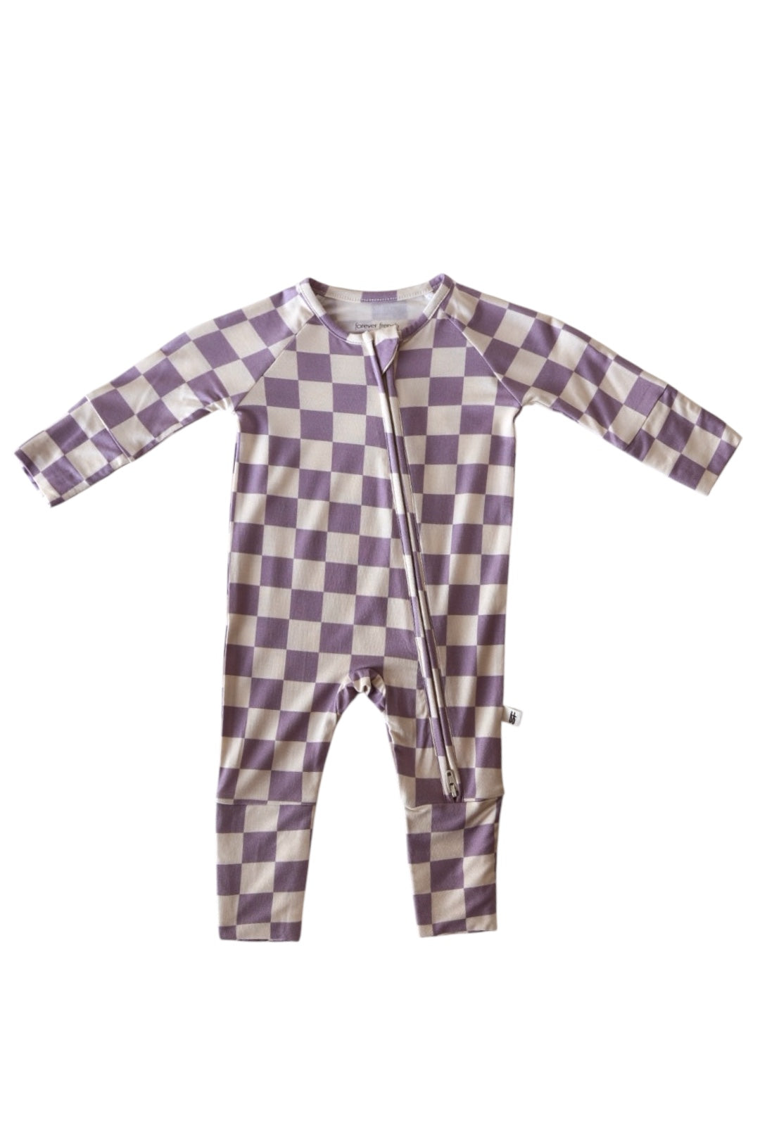 The Bamboo Zip Pajama | Grape Soda by forever french baby features long sleeves, a purple and cream checkerboard pattern, breathable fabric, and a diagonal zipper from the neckline to the left leg.