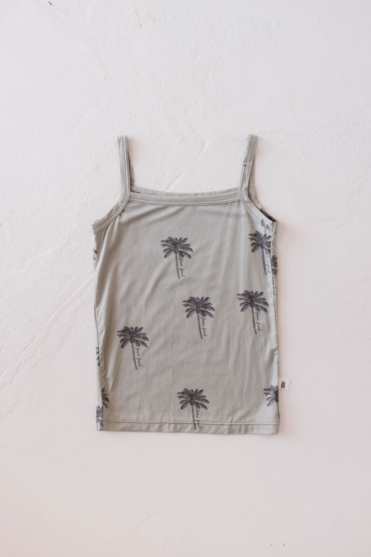 The Basic Bamboo Tank | Summer Dreamin' by forever french baby, crafted from hypo-allergenic bamboo fabric and featuring a pattern of small black palm trees, is laid flat against a white textured background. This light gray tank top boasts thin shoulder straps and a straight neckline.