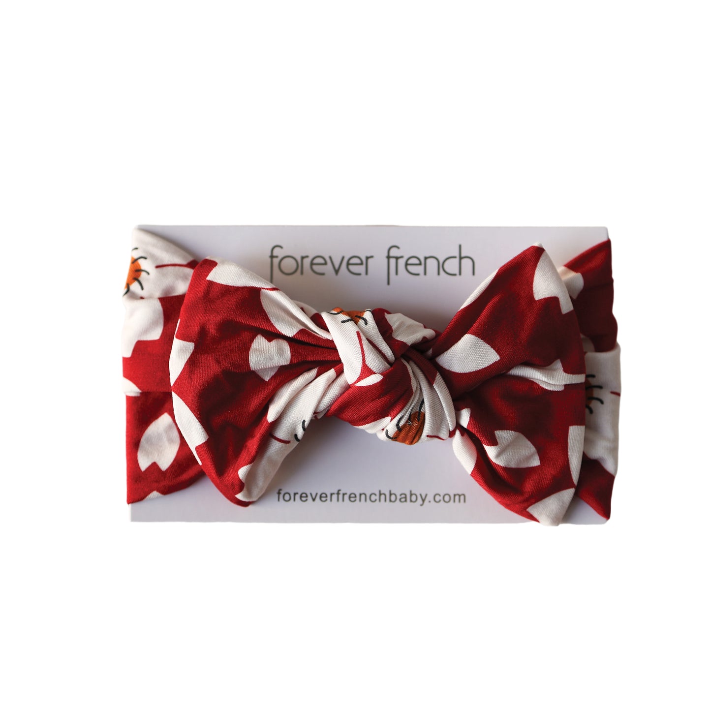 The Bamboo Head Wrap | Cherry Blossoms by forever french baby features a red and white pattern with a large bow, displayed on a branded card.