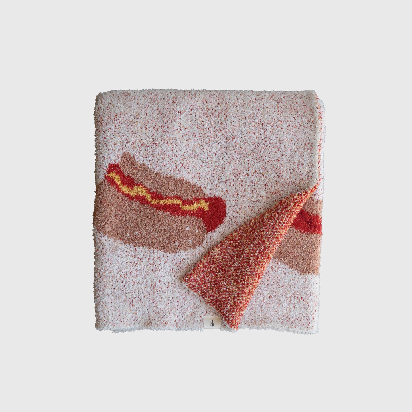 The Plush Blanket | Hot Dogs by forever french baby is a square, speckled microfiber blanket with a hot dog and zigzag mustard design. One corner is folded to show the reverse of this Oeko-Tex certified fabric.