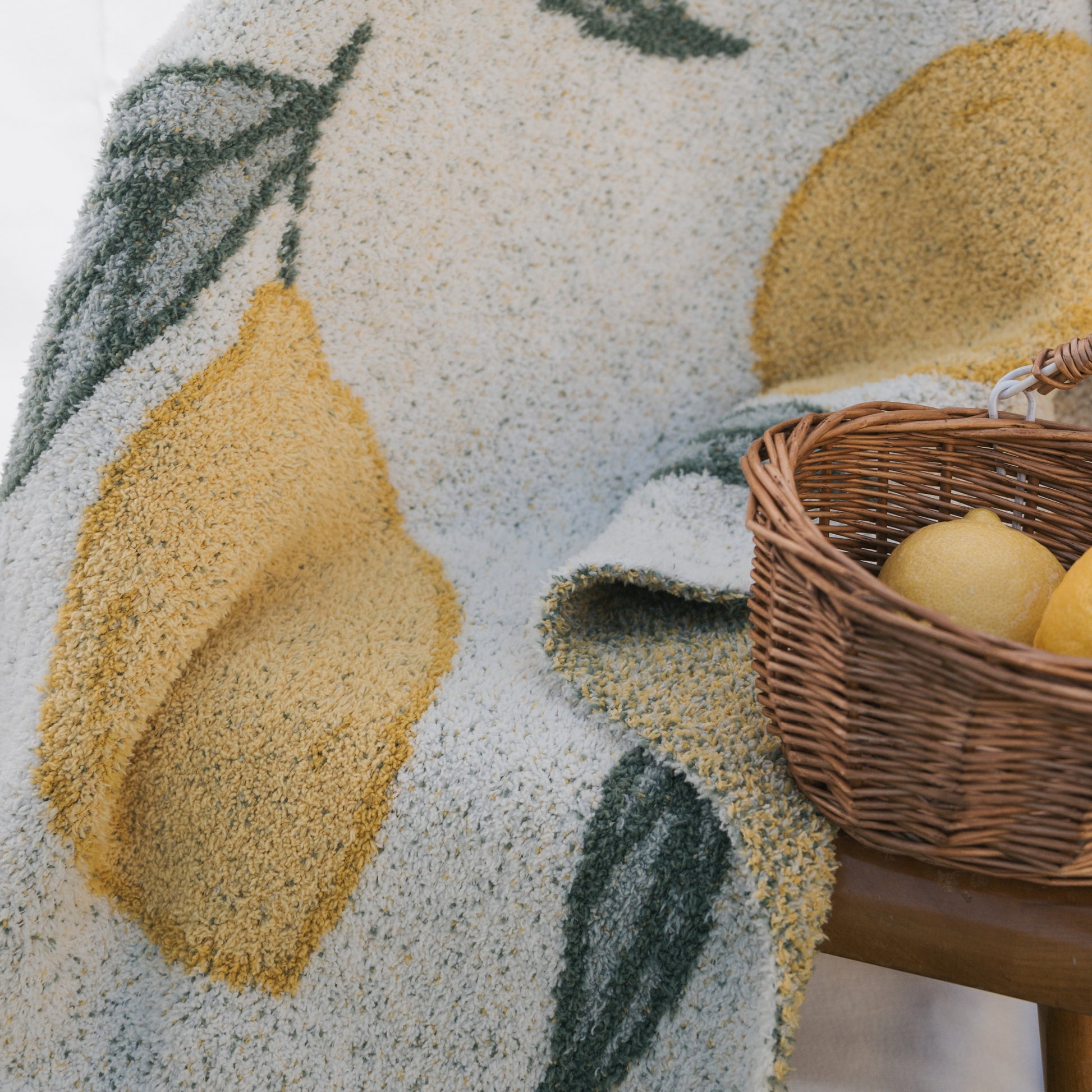 The forever french baby *PRE-ORDER* Plush Blanket | Lemon, made from Oeko-tex certified microfiber, features a yellow lemon and green leaf pattern—gentle for little ones and a stylish addition to any space.