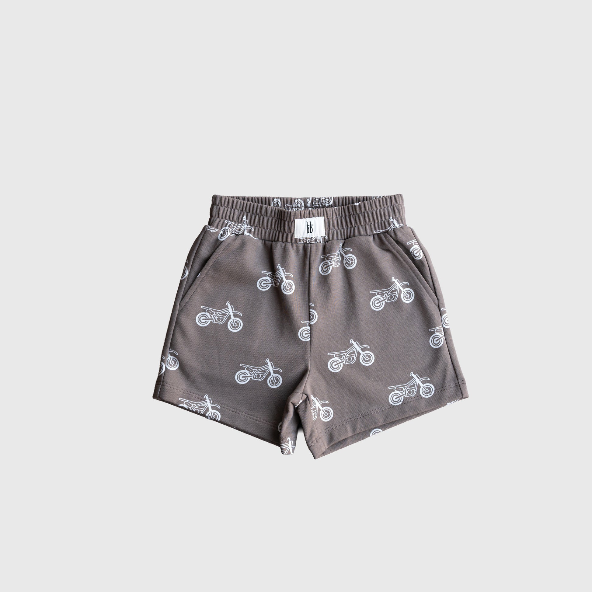 The forever french baby French Terry Short Set | Dirt Bike features gray children's shorts with an elastic waistband, side pockets, and a white motorcycle print—great to pair as a cool kids matching set. Displayed on a plain light gray background.