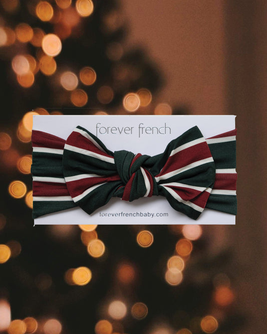Forever French Baby Bamboo Head Wrap | Holiday Stripe featuring a dark green, white, and red knotted pattern on a display card.
