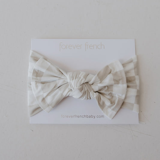 The Bamboo Head Wrap | Checkerboard from forever french baby is shown in beige and white on a white card labeled "forever french," with "foreverfrenchbaby.com" printed below.