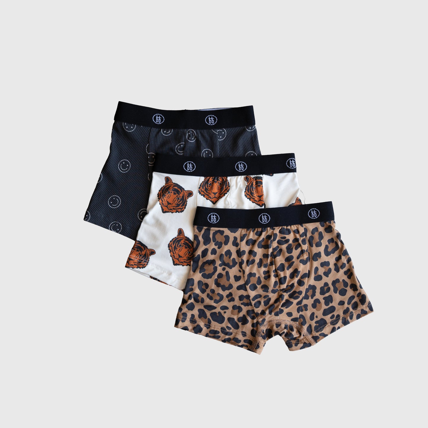 The forever french baby Bamboo Boxers (3 Pack) includes men's ribbed boxers with leopard print, tiger faces on white, and black-and-white smiley faces. Each features a black waistband with a white logo for comfort and style.