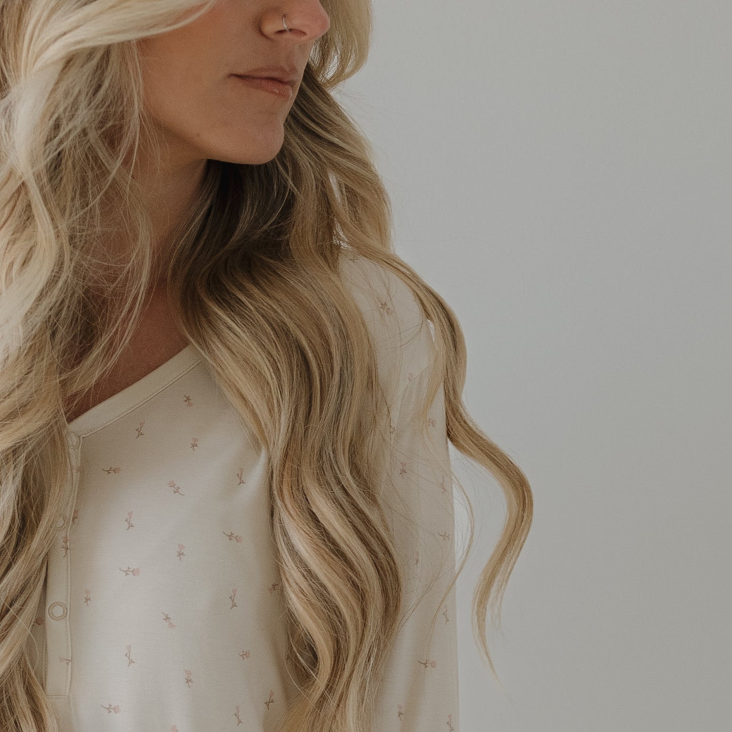 A woman with long, wavy blonde hair models the Women's Long Sleeve Bamboo Pajama | Lucy by forever french baby. The cropped photo shows her from shoulders up, face partially out of frame, against a plain background.