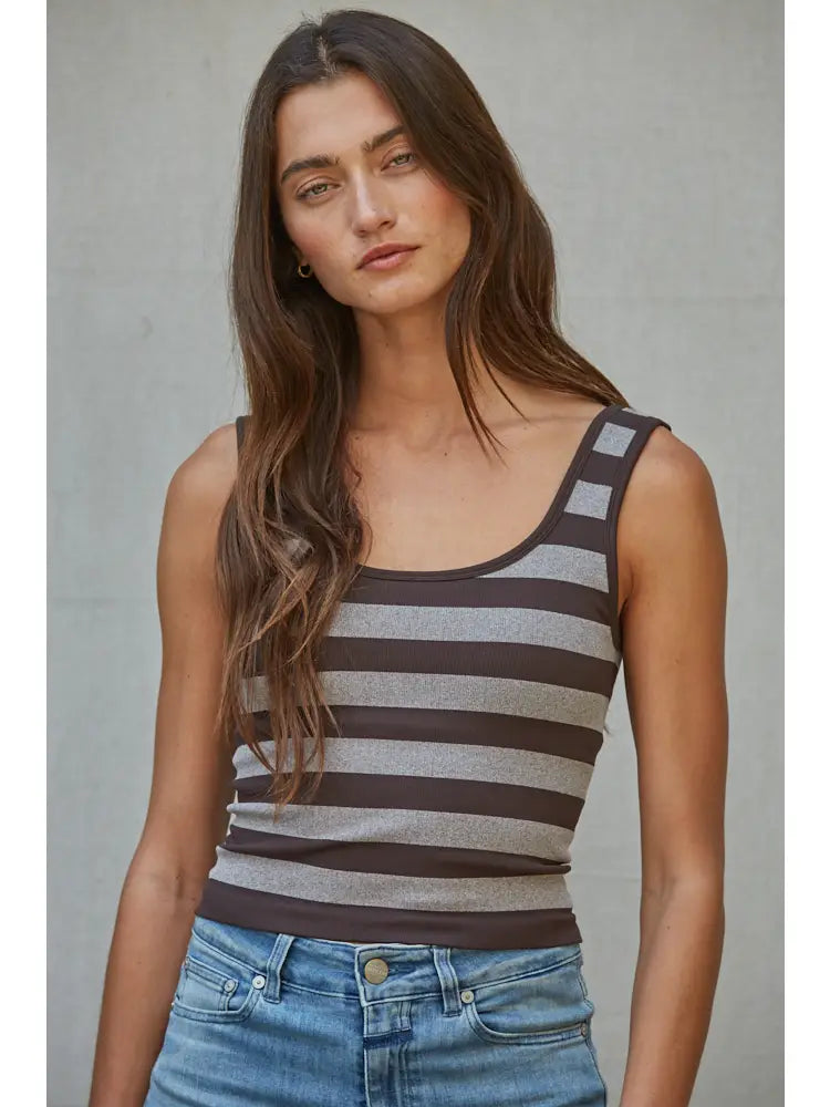A woman with long brown hair wears the forever french baby Knit Striped Seamless Padded Tank Top and blue jeans, standing against a plain gray background.