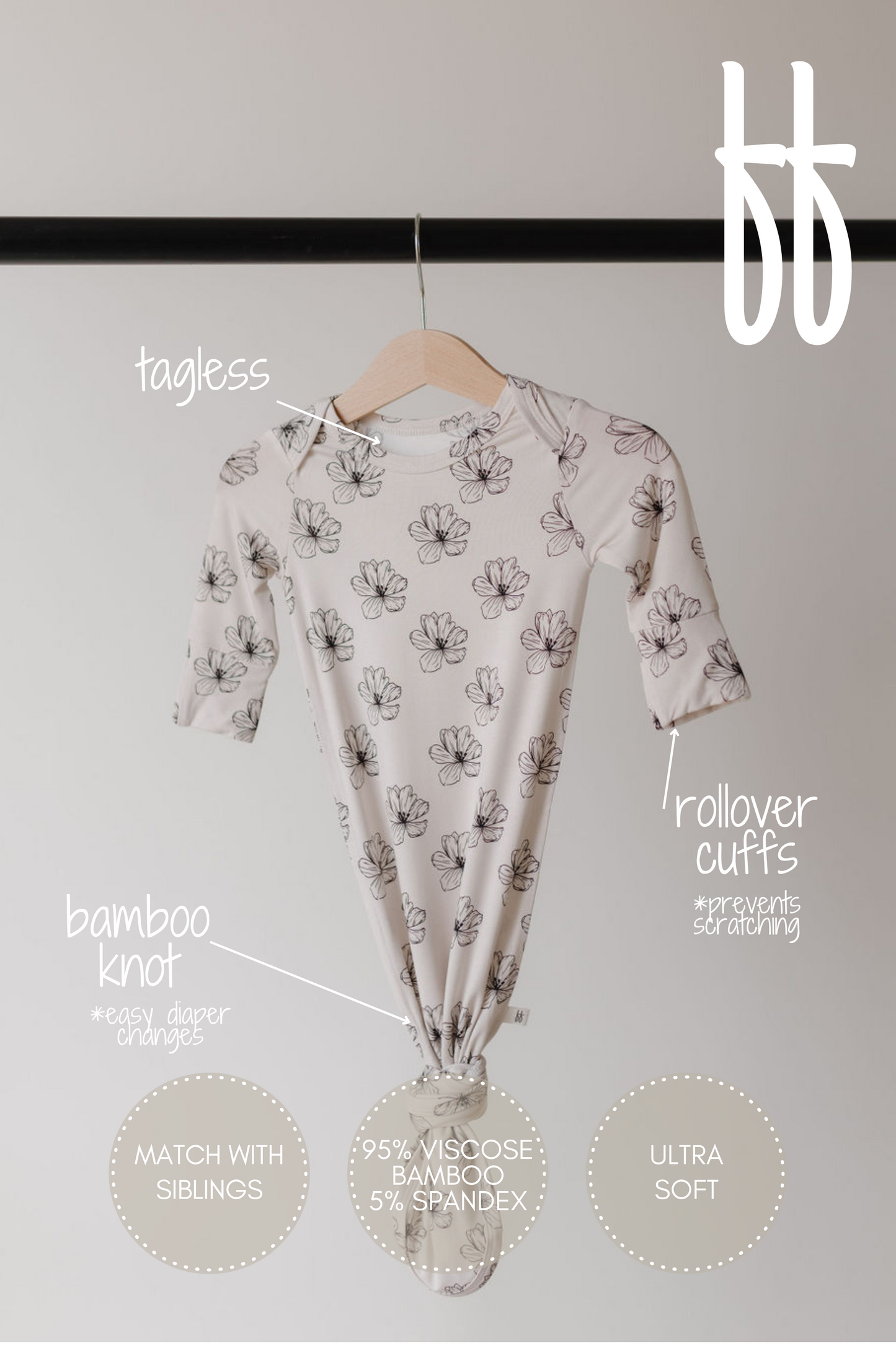 The "Bamboo Knotted Gown | Desert Bloom" by forever french baby hangs on a wooden hanger. Hypo-allergenic with a bamboo knot, rollover cuffs, and tagless design, it offers ultra-soft fabric, easy diaper changes, prevents scratching, and can match with siblings.