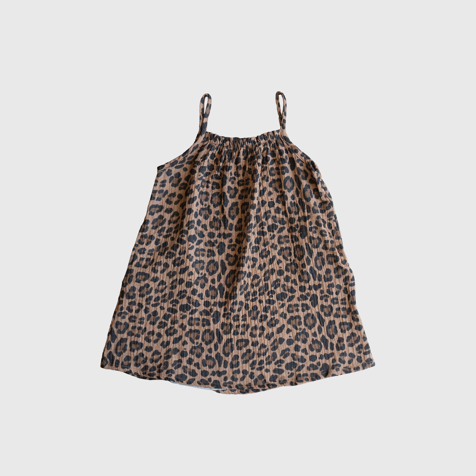 The forever french baby Child Muslin Sleeveless Dress | Leopard features a sleeveless, knee-length design with spaghetti straps and a brown and black leopard print, shown on a plain white background.