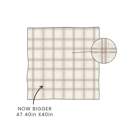 The forever french baby Bamboo Swaddle | Ellis Plaid features a breathable beige and brown plaid fabric. Text reads "NOW BIGGER AT 40in X 40in," with an arrow to the swaddle and a circular magnifier showcasing the plaid pattern.
