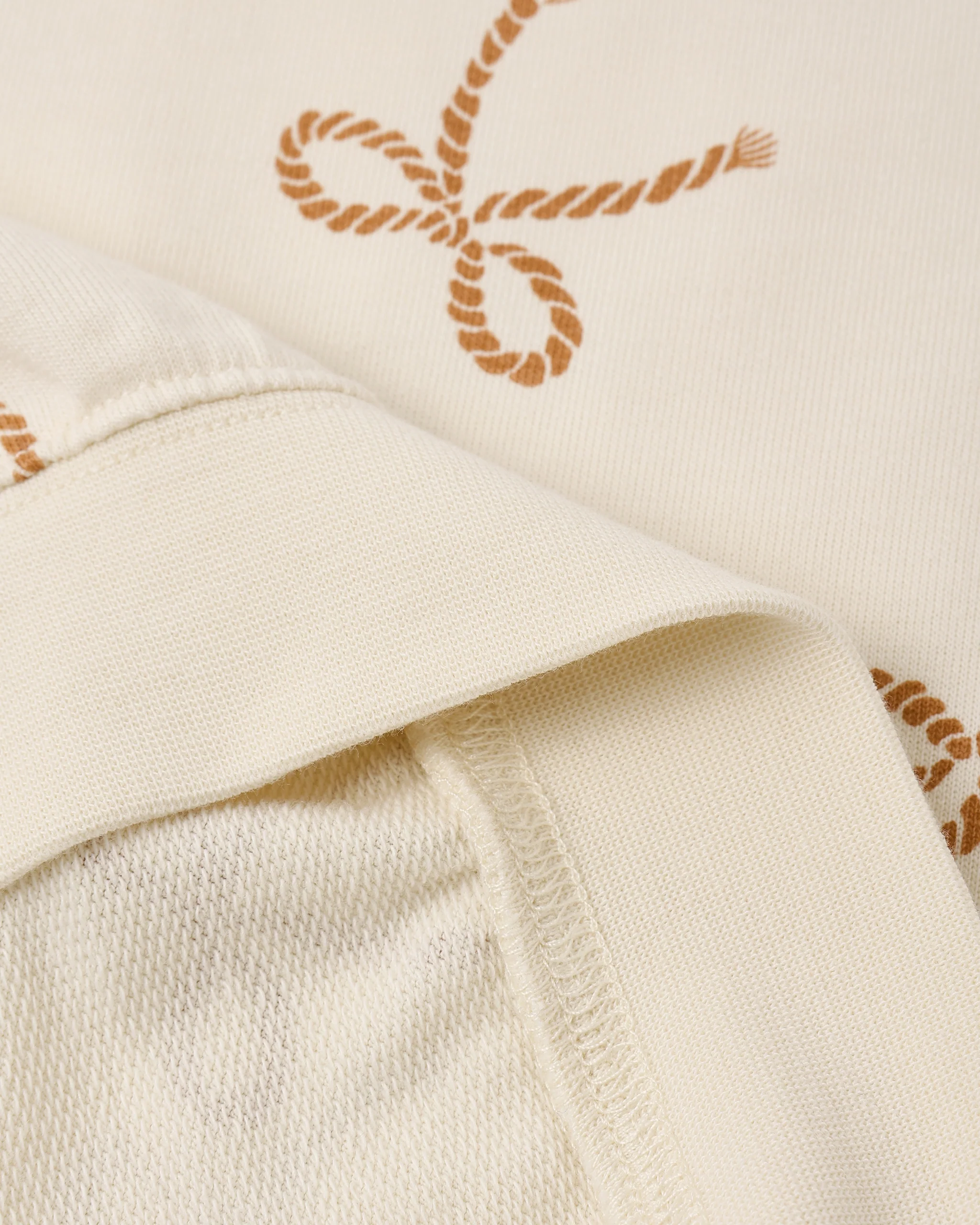 Close-up of Rylee + Cru's Summer Terry Set | Sailor Bows, showing cream fabric with brown sailor bows, detailed stitching, and inner seam—highlighting the set’s quality texture.