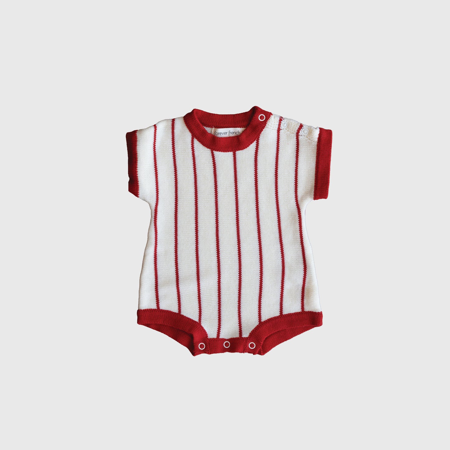 The Knit Romper | Picnic Pinstripe by forever french baby features red and white vertical stripes, red trim, is made from 100% cotton, and includes snap buttons at the bottom for easy changing.