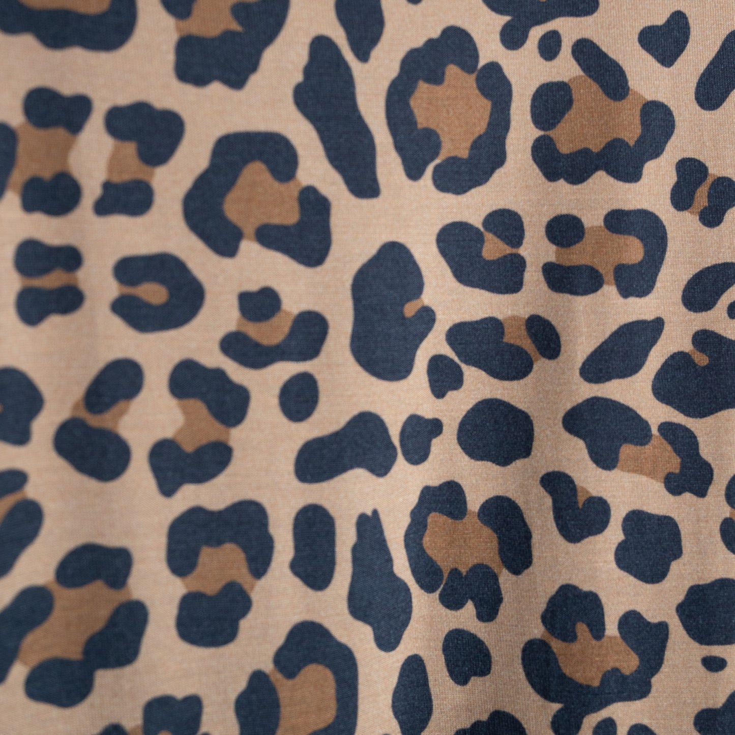 Close-up of forever french baby's Women's Bamboo Short Set | Leopard, crafted from hypoallergenic bamboo with brown and black leopard spots on a light tan background. The print features irregular, organic-shaped patterns across the fabric.