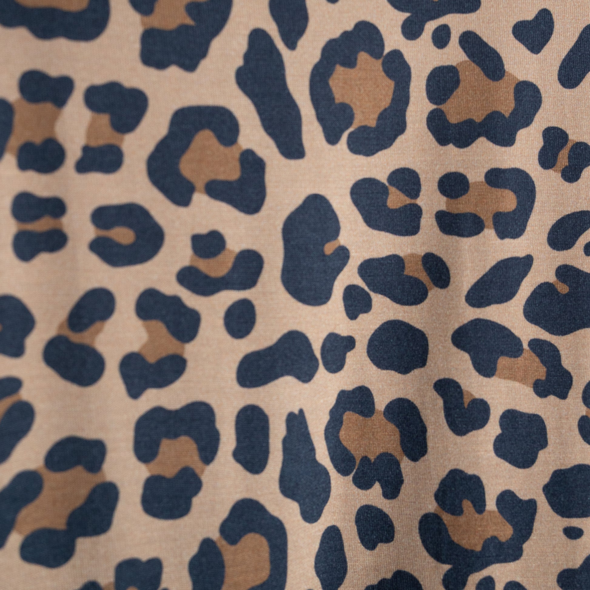 Close-up of forever french baby's Women's Bamboo Short Set | Leopard, crafted from hypoallergenic bamboo with brown and black leopard spots on a light tan background. The print features irregular, organic-shaped patterns across the fabric.