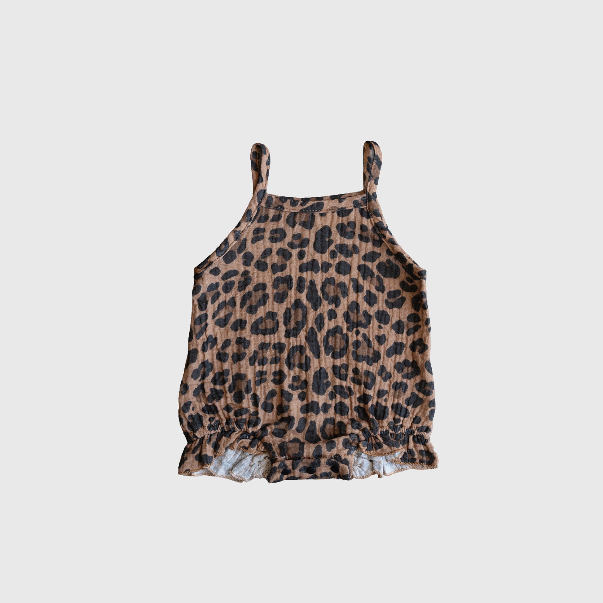 The Muslin Sleeveless Tank Romper in leopard print by forever french baby features thin straps, a ruffled hem, and a brown and black leopard pattern—an adorable baby outfit shown on a plain white background.