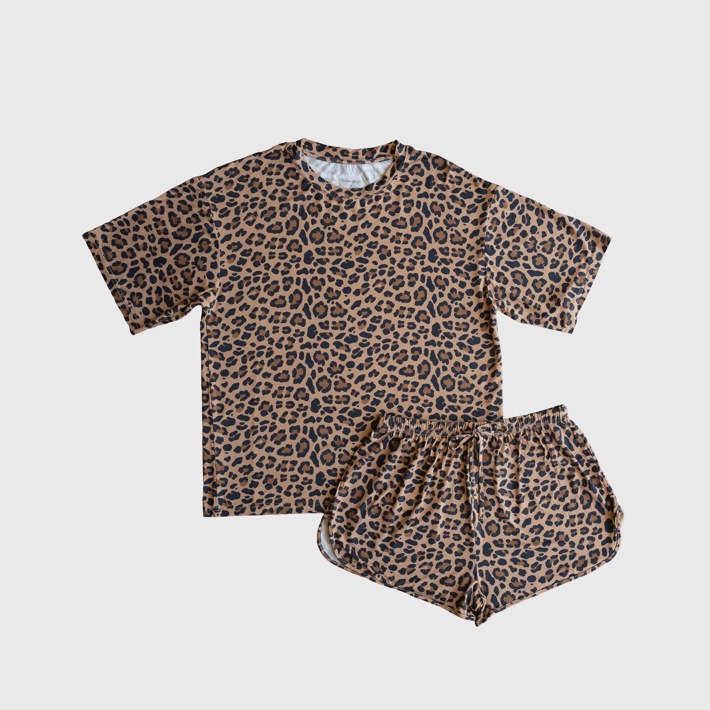 The forever french baby Women's Bamboo Short Set | Leopard features a brown T-shirt and shorts with an all-over black leopard print, made from soft bamboo fabric and displayed flat on a white background.