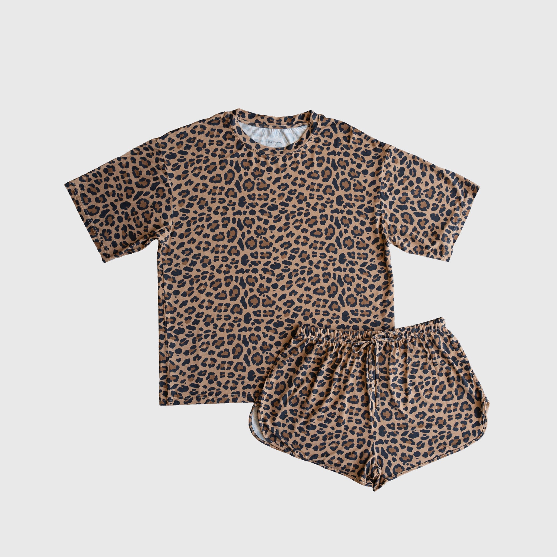 The forever french baby Women's Bamboo Short Set | Leopard features a brown T-shirt and shorts with an all-over black leopard print, made from soft bamboo fabric and displayed flat on a white background.