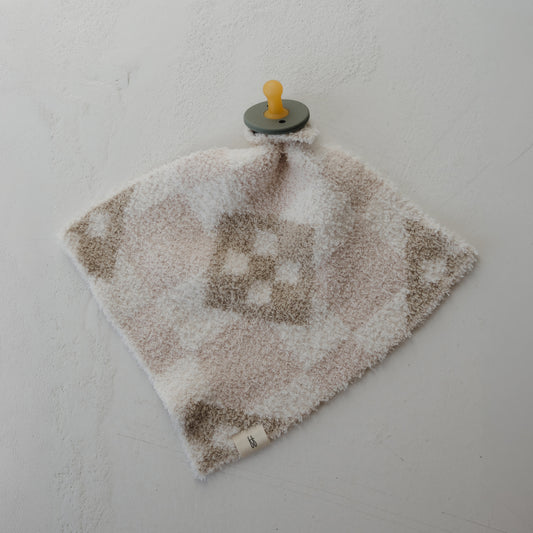 The Lovey | Cottage Quilt by forever french baby is a soft, square comfort blanket with a beige and white check pattern, made from cozy microfiber feather yarn, featuring an attached pacifier and shown on a light textured surface.