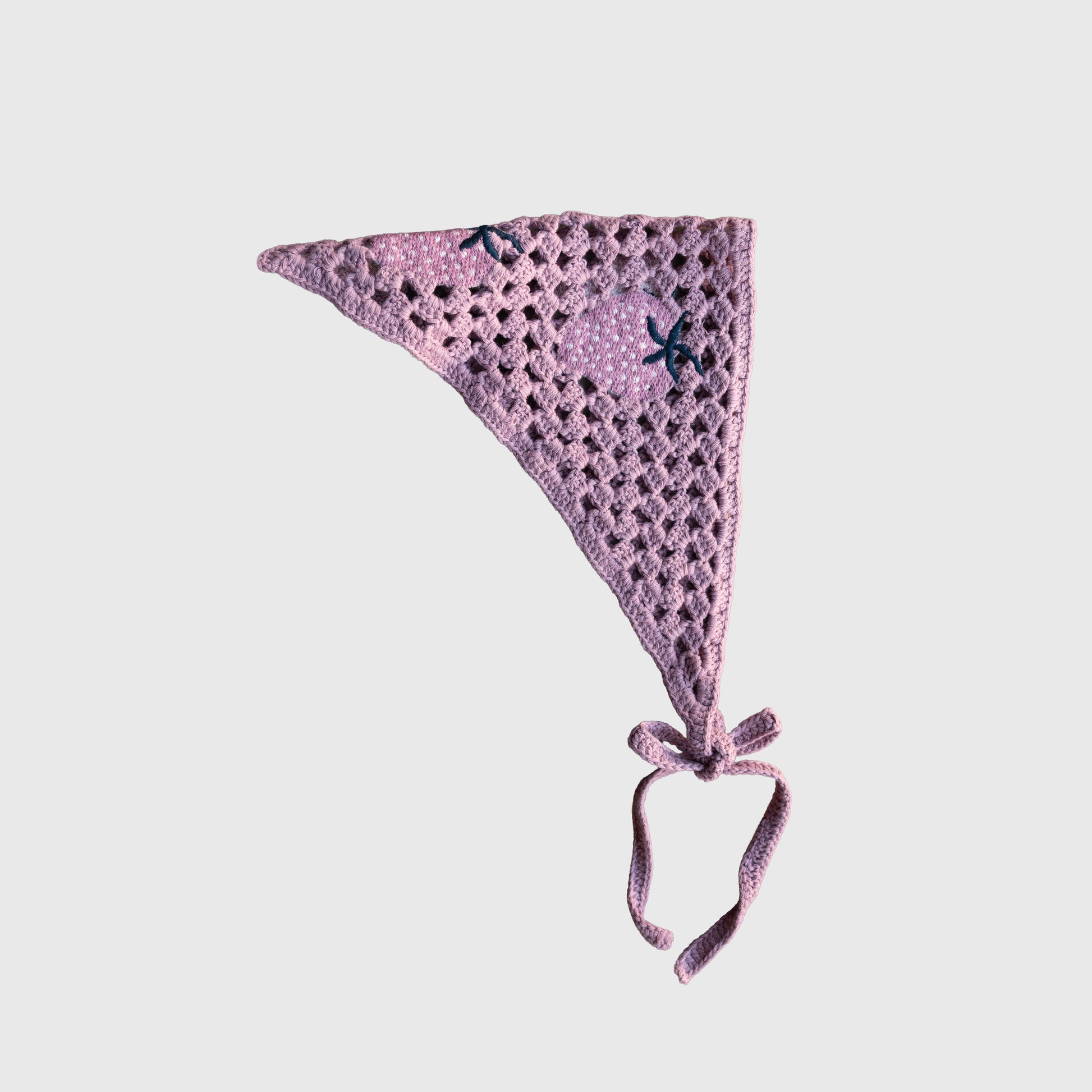 The Knit Head Scarf | Matilda by forever french baby is a lavender, crocheted triangular head scarf made from soft cotton yarn, showcasing an open, lacy pattern and finished with two long adjustable ties at the bottom. It is shown against a plain white background.