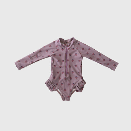 The Matilda Girl's Long Sleeve Swimsuit by forever french baby features a light pink one-piece with ruffled hips, front zipper, and a cute red strawberry pattern.
