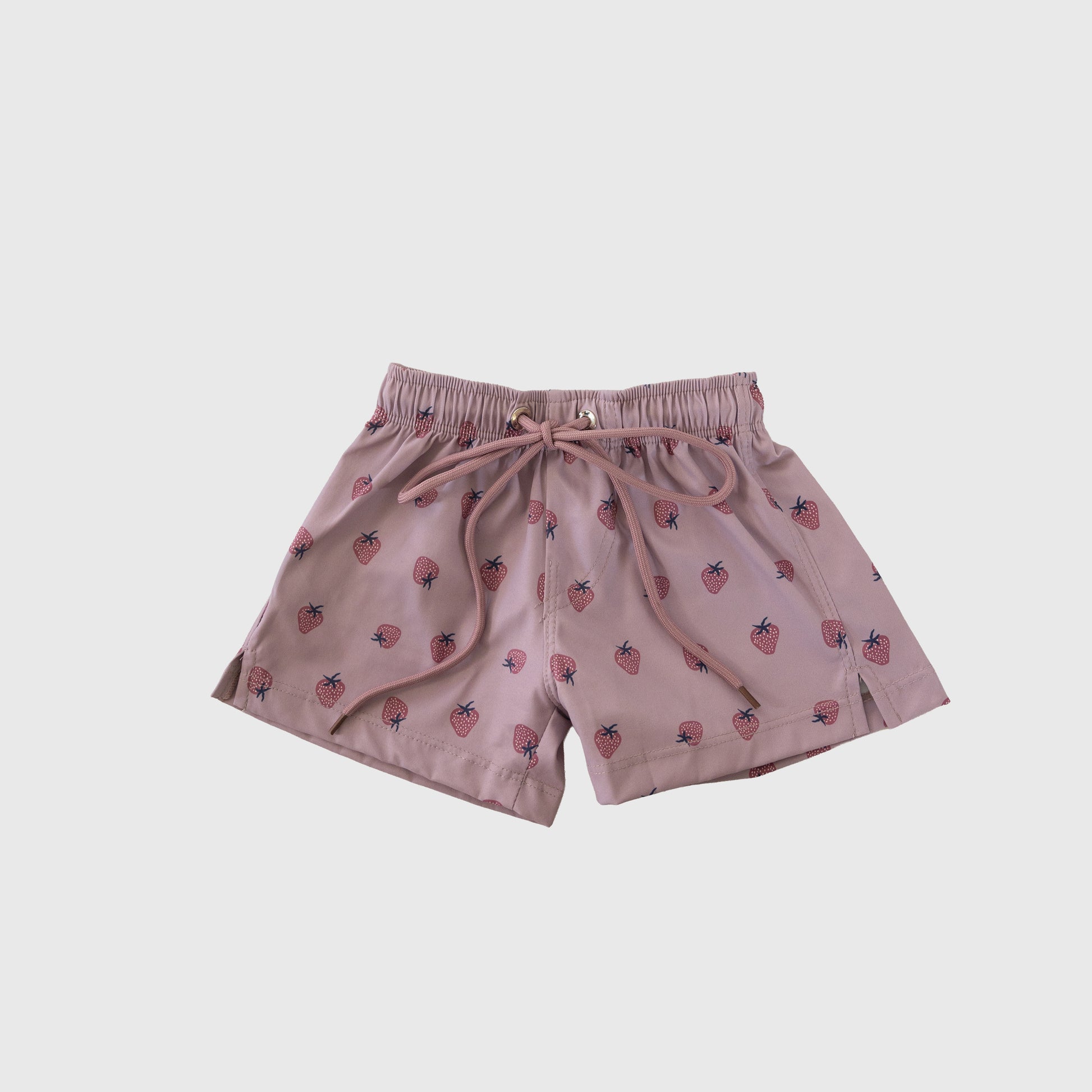The Child Board Short | Matilda by forever french baby features light pink fabric, a drawstring waistband, and playful strawberry and blue leaf prints—ideal for kids' swimwear or summer outfits.