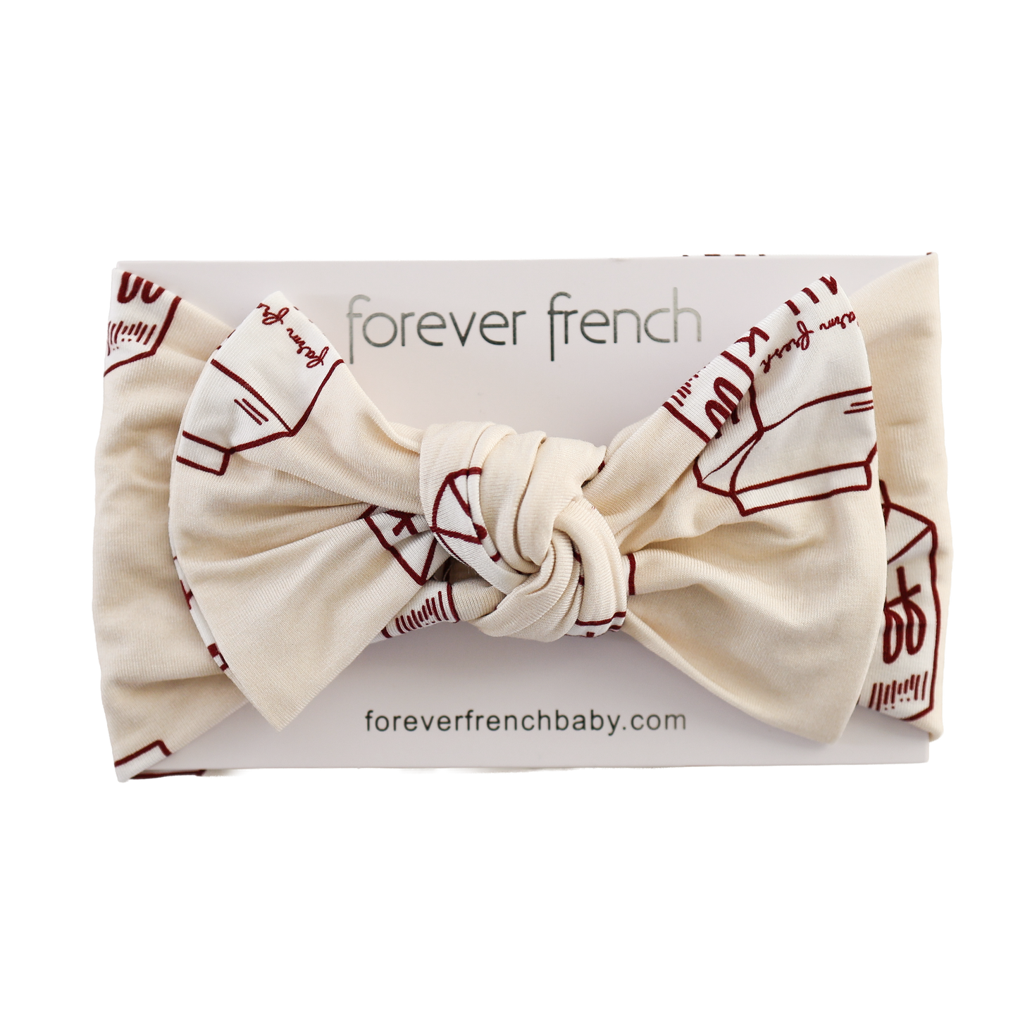 The Bamboo Head Wrap | Milk by forever french baby is a cream-colored bamboo baby headband with maroon designs, knotted and displayed on a "forever french baby" card. Find it at foreverfrenchbaby.com.