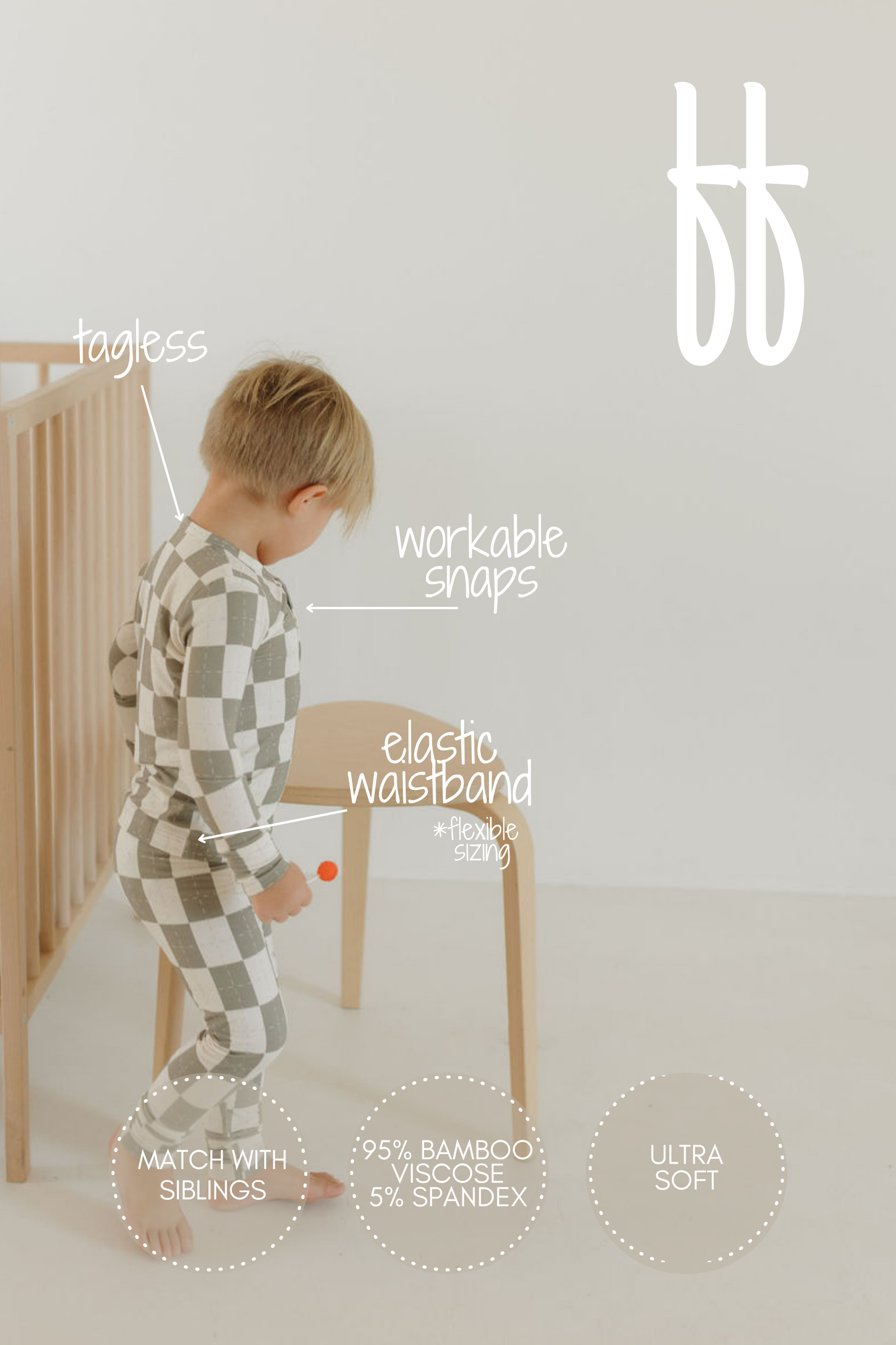 A child in a checkered onesie stands next to a wooden crib, clutching a toy. The ultra-soft set features tagless design, workable snaps, and an elastic waistband. Made with 95% bamboo viscose and 5% spandex for breathability—ideal for matching with siblings in forever french baby pajamas.