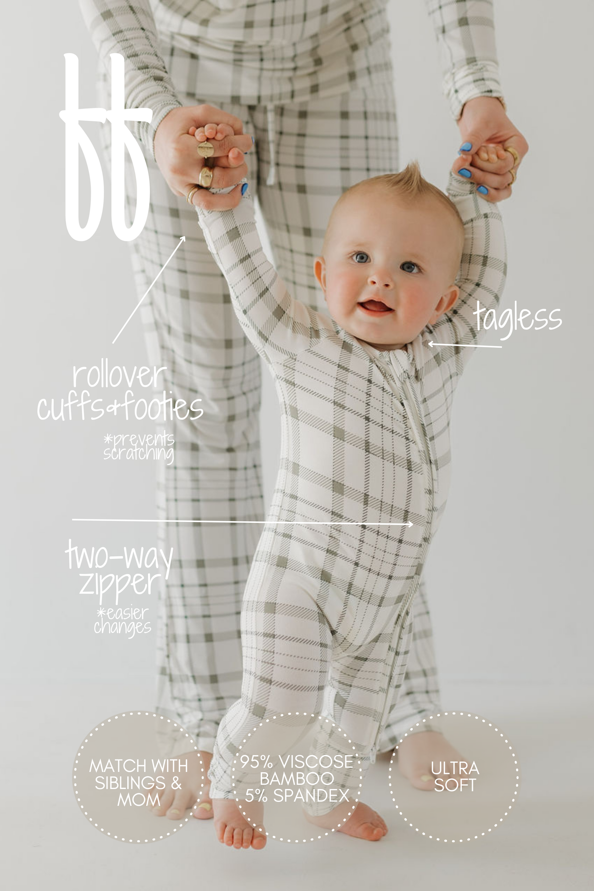 A baby in "forever french baby's Bamboo Zip Pajamas | Picnic Plaid" is held by an adult in matching attire. These pajamas have rollover cuffs, footies, a tagless design, and a two-way zipper. Their exceptionally soft, breathable, and hypoallergenic fabric makes them ideal for family matching.